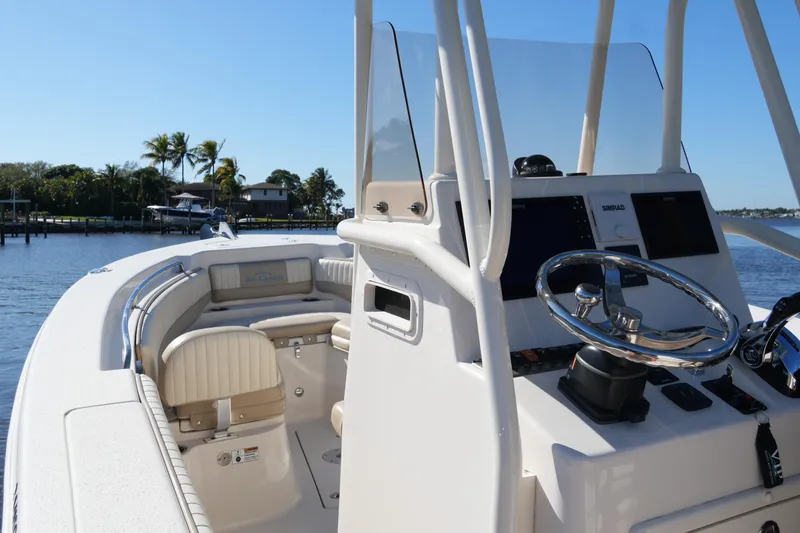 Slide: The Image of 2019 SeaChaser 24 HFC boat interior with steering console and seating, dockside view. - 30