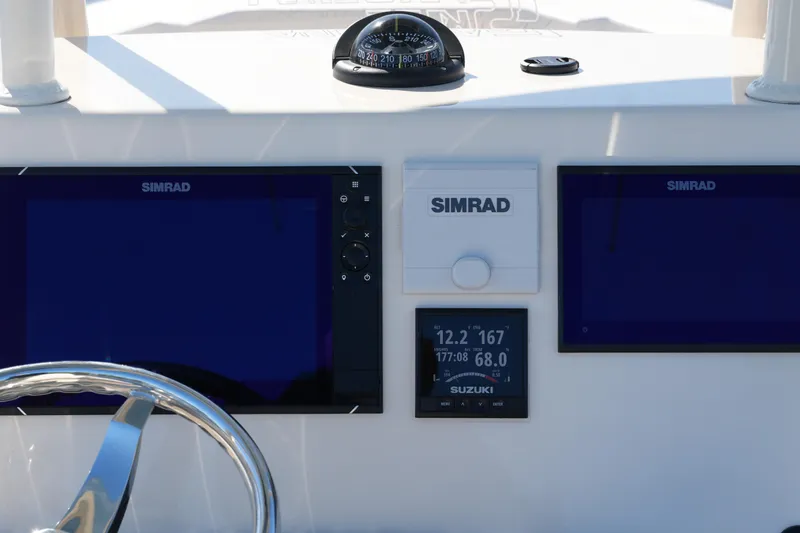 Slide: The Image of 2019 SeaChaser 24 HFC dashboard with Simrad displays and Suzuki gauge. - 33