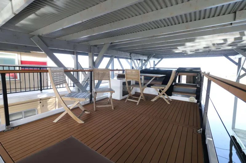 Slide: The Image of Modern Navisyo Homes NV.08 houseboat deck with wooden flooring and seating, 2021 model. - 18
