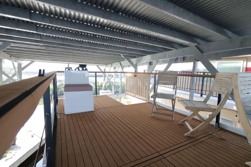 Slide: The Image of Navisyo Homes NV.08 2021 model with wooden deck and seating area under a metal roof. - 19