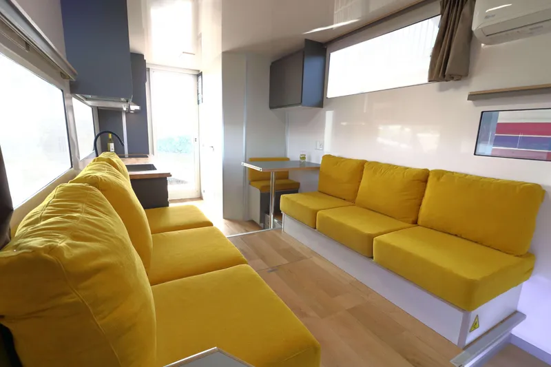 Slide: The Image of Modern Navisyo Homes NV.08 interior, 2021 model, featuring bright yellow seating and sleek design. - 2