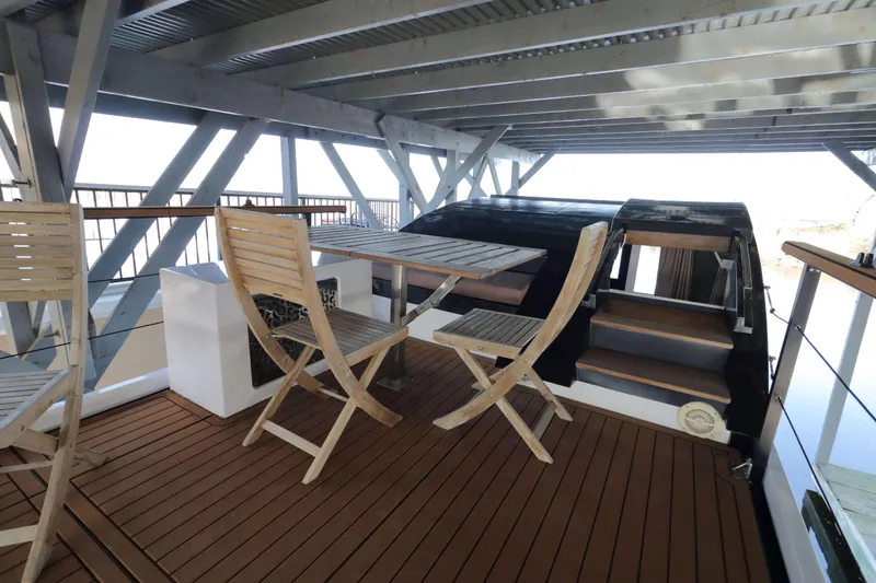 Slide: The Image of Navisyo Homes NV.08 2021 model with wooden deck and outdoor seating area. - 20