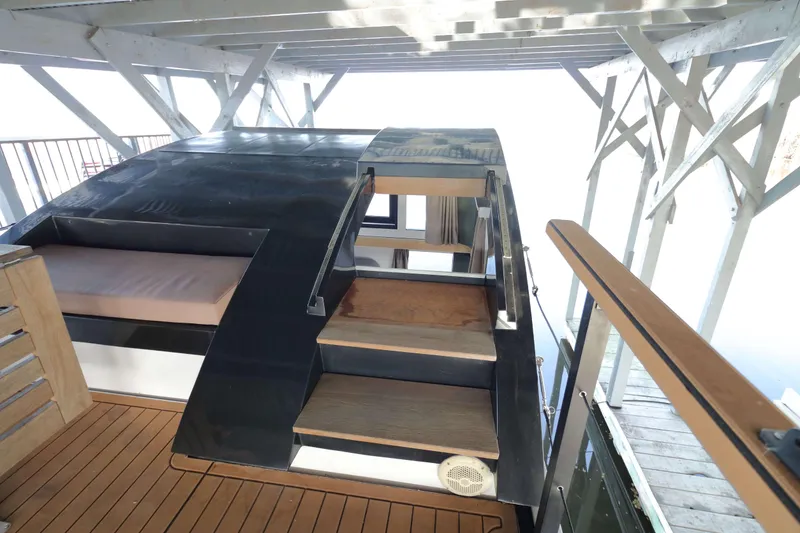 Slide: The Image of Navisyo Homes NV.08 houseboat, 2021 model, featuring wooden deck and stairs under a covered dock. - 22