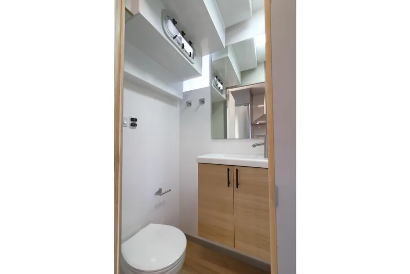 Slide: The Image of Compact modern bathroom in Navisyo Homes NV.08, 2021 model, featuring sleek fixtures and wooden cabinetry. - 25