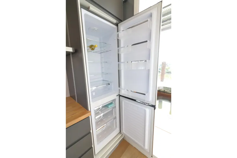 Slide: The Image of Open refrigerator in Navisyo Homes NV.08, 2021 model, showcasing spacious interior and modern design. - 30