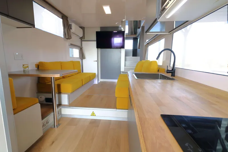 Slide: The Image of Modern Navisyo Homes NV.08 interior with yellow seating, wooden countertops, and sleek design, 2021 model. - 7