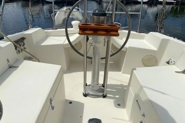 Slide: The Image of 1977 C&C 29 sailboat cockpit with steering wheel and seating, docked at marina. - 12