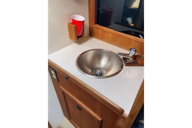 Slide: The Image of 1977 C&C 29 yacht interior with stainless steel sink and wooden cabinetry. - 19