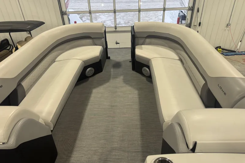 Slide: The Image of Interior of 2022 Lowe SS 270 pontoon boat with spacious seating in a garage. - 13