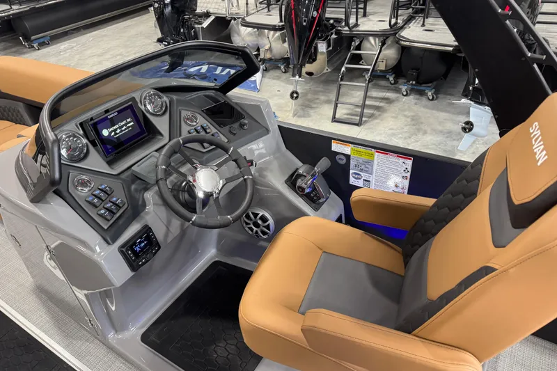 Slide: The Image of 2026 Sylvan L-5 Platinum boat dashboard with modern controls and tan seating. - 11