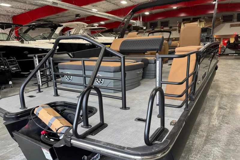 Slide: The Image of 2026 Sylvan L-5 Platinum pontoon boat with tan seating in showroom. - 6