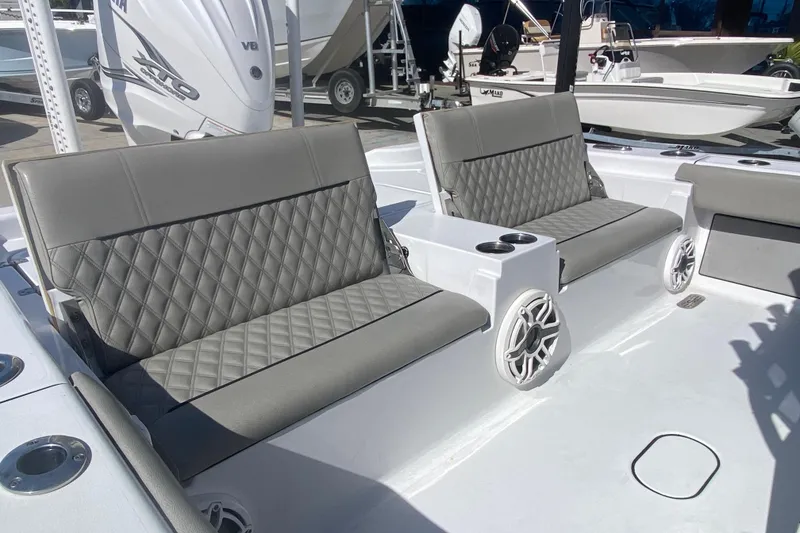 Slide: The Image of 2021 Sportsman Masters 267 Bay Boat interior with gray quilted seating and cup holders. - 21