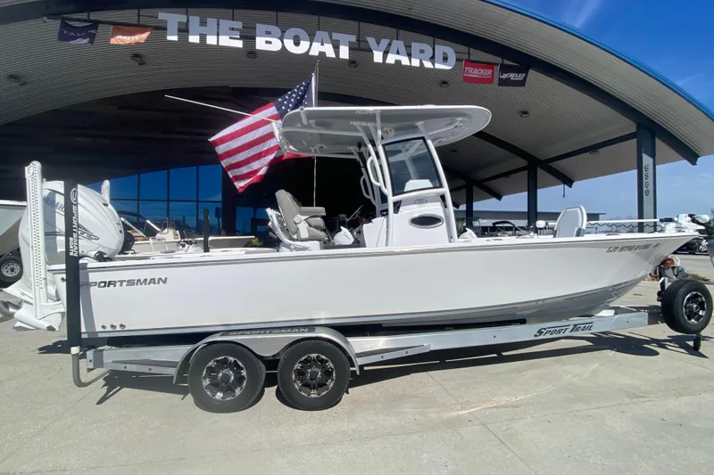 Slide: The Image of 2021 Sportsman Masters 267 Bay Boat on trailer at dealership, American flag displayed. - 3