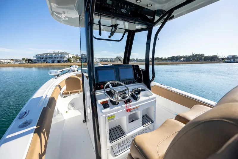Slide: The Image of 2022 Sea Hunt Gamefish 25 boat interior with modern controls and scenic water view. - 11