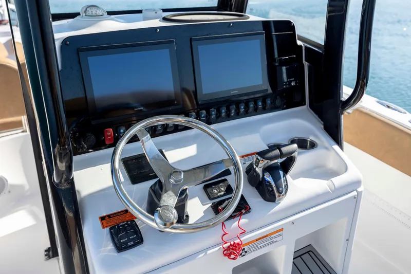 Slide: The Image of 2022 Sea Hunt Gamefish 25 helm with dual displays and steering wheel. - 12