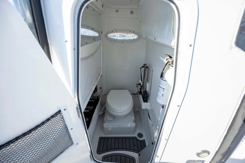 Slide: The Image of 2022 Sea Hunt Gamefish 25 boat interior with compact marine toilet and safety equipment. - 18