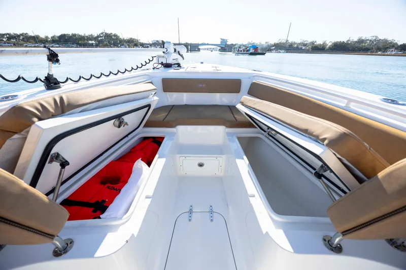 Slide: The Image of 2022 Sea Hunt Gamefish 25 boat interior with open storage compartments and life jackets. - 19