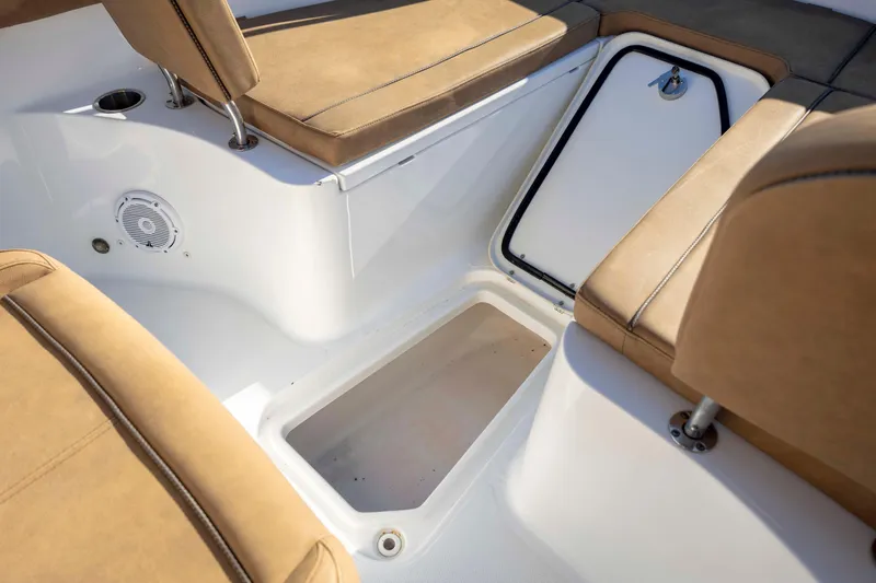 Slide: The Image of 2022 Sea Hunt Gamefish 25 boat interior with tan seating and storage compartment. - 20