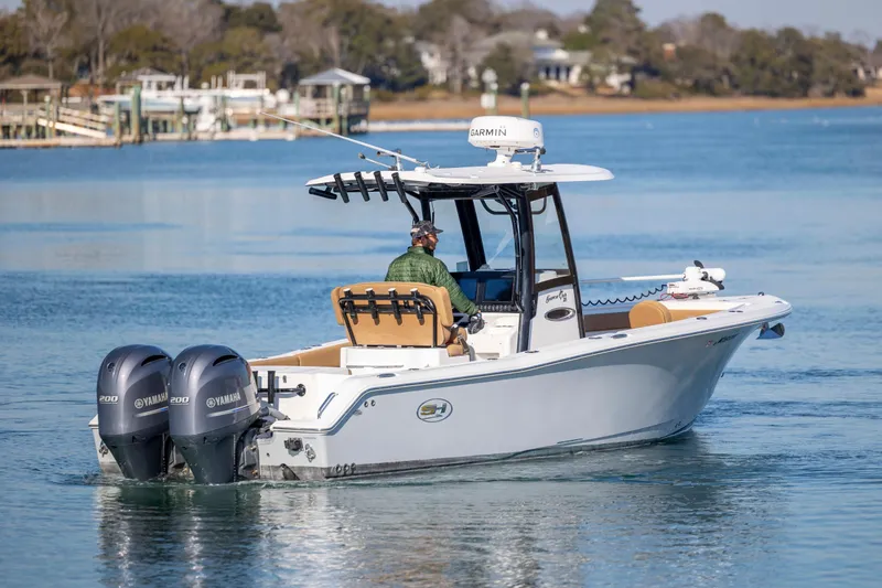 Slide: The Image of 2022 Sea Hunt Gamefish 25 boat with dual Yamaha engines on a calm lake. - 4