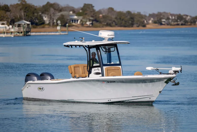 Slide: The Image of 2022 Sea Hunt Gamefish 25 boat cruising on calm waters with scenic background. - 5