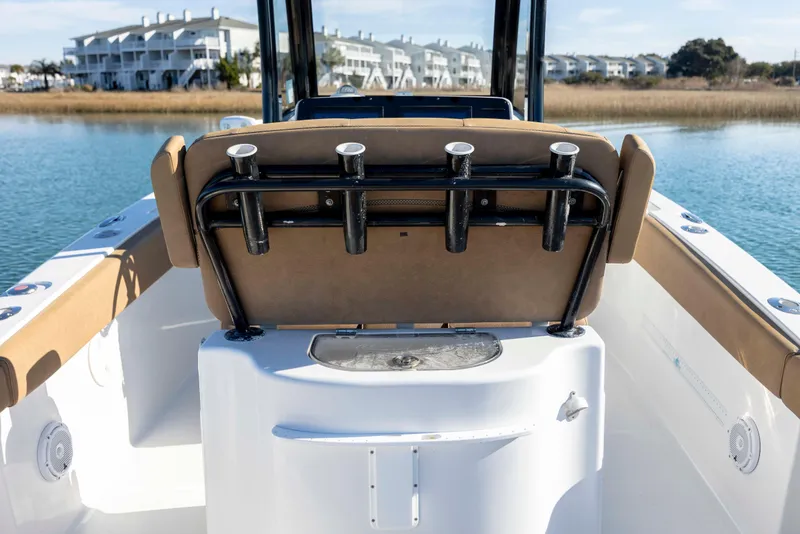 Slide: The Image of 2022 Sea Hunt Gamefish 25 boat interior with rod holders, on calm water. - 8