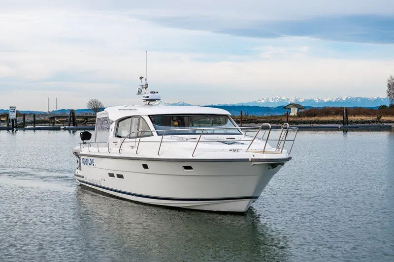 Slide: The Image of 2023 Nimbus 405 Coupé cruising on calm waters with scenic mountain backdrop. - 17