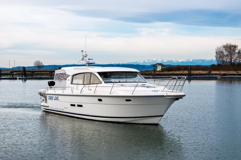 Slide: The Image of Nimbus 405 Coupé 2023 cruising on calm waters with scenic mountain backdrop. - 18