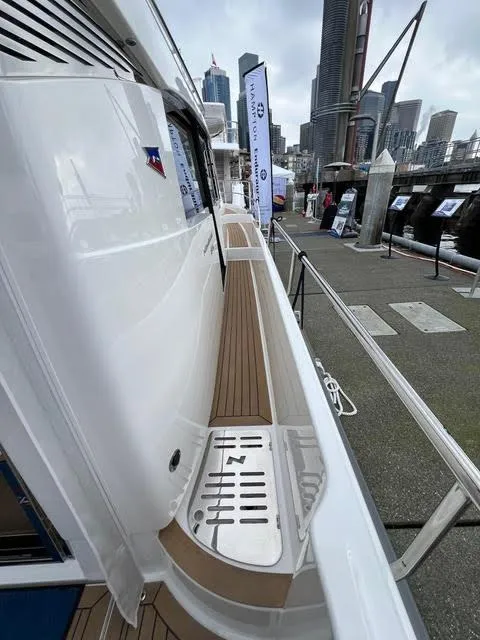 Slide: The Image of 2023 Nimbus 405 Coupé boat named "Crazy Love" cruising near a dock with mountains in background. - 2