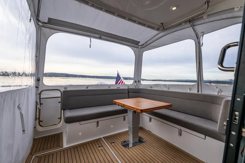Slide: The Image of Interior of 2023 Nimbus 405 Coupé yacht with seating and table, overlooking water. - 21