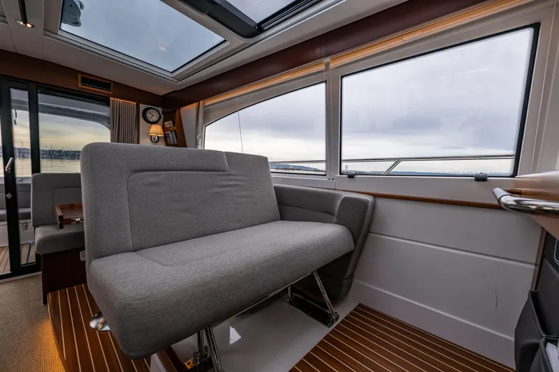 Slide: The Image of Interior of 2023 Nimbus 405 Coupé yacht with modern seating and panoramic windows. - 24