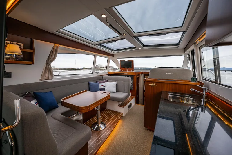 Slide: The Image of Luxurious interior of 2023 Nimbus 405 Coupé yacht with panoramic windows and elegant furnishings. - 25
