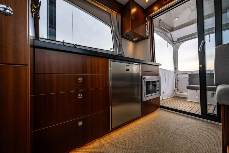 Slide: The Image of Luxurious interior of 2023 Nimbus 405 Coupé yacht with modern kitchen and elegant wood finish. - 26