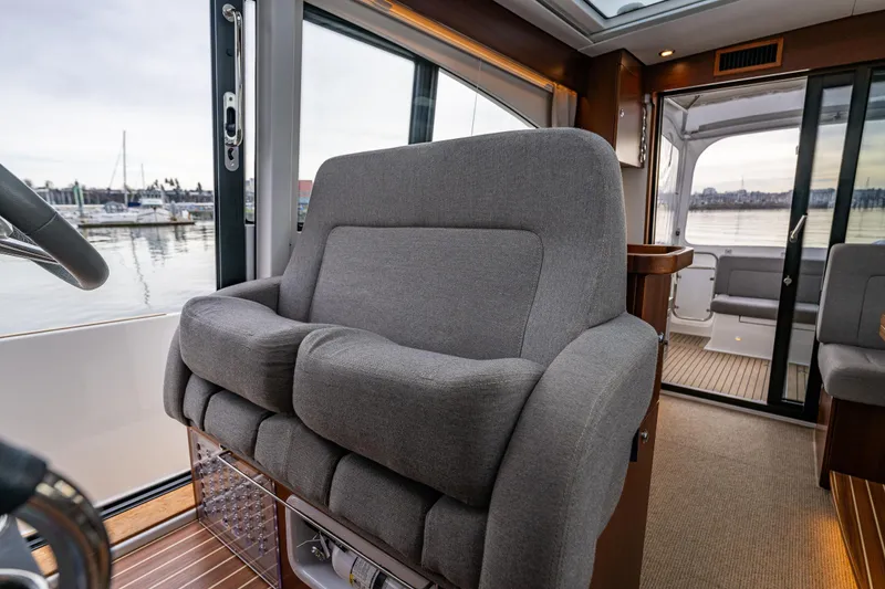 Slide: The Image of Luxurious interior of 2023 Nimbus 405 Coupé yacht with plush seating and scenic marina view. - 29