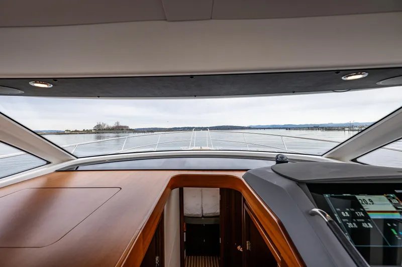 Slide: The Image of Interior view from the helm of a 2023 Nimbus 405 Coupé yacht, overlooking calm waters. - 30