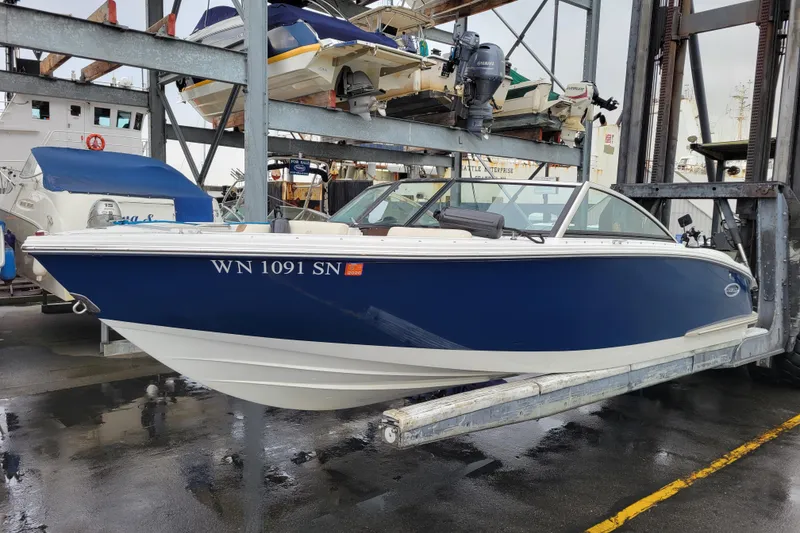 The Image of 2016 Cobalt CS3 boat in storage, blue and white design, marina setting. - 0
