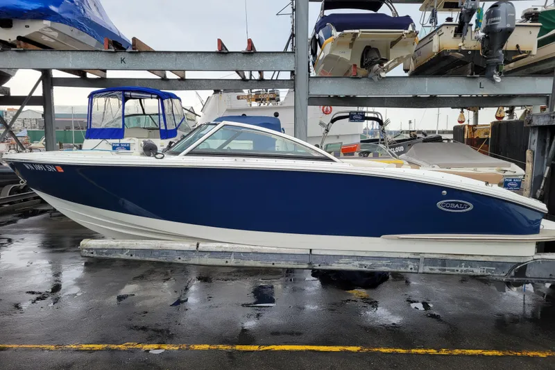 Slide: The Image of 2016 Cobalt CS3 boat in blue and white on a marina rack. - 1