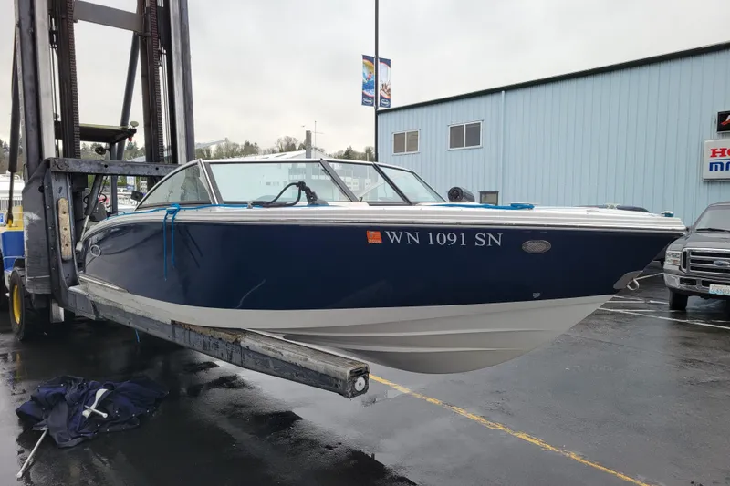 Slide: The Image of 2016 Cobalt CS3 boat on forklift at marina, blue hull, overcast day. - 5