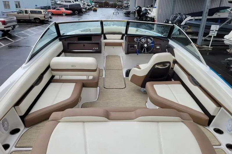 Slide: The Image of 2016 Cobalt CS3 boat interior with beige and brown seating, parked in a marina. - 8