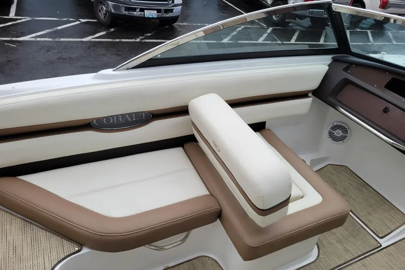 Slide: The Image of 2016 Cobalt CS3 boat interior with beige and brown seating, parked in a lot. - 9
