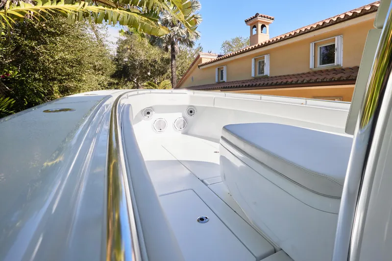 Slide: The Image of 2024 Contender 35 ST boat interior with seating, surrounded by lush greenery and a house. - 11