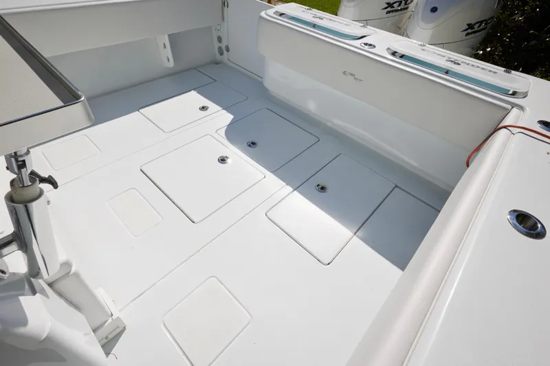 Slide: The Image of 2024 Contender 35 ST boat deck with storage compartments and outboard engines. - 14
