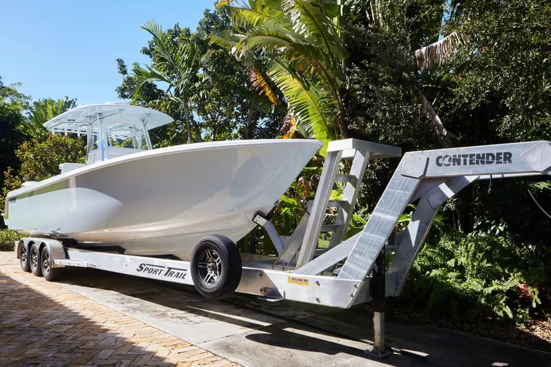 Slide: The Image of 2024 Contender 35 ST boat on trailer, surrounded by lush greenery. - 2