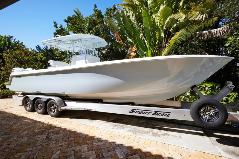 Slide: The Image of 2024 Contender 35 ST boat on trailer, surrounded by lush greenery. - 5