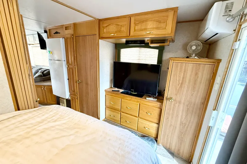 Slide: The Image of 2006 Myacht 4313 interior with TV, wooden cabinets, and air conditioning unit. - 10