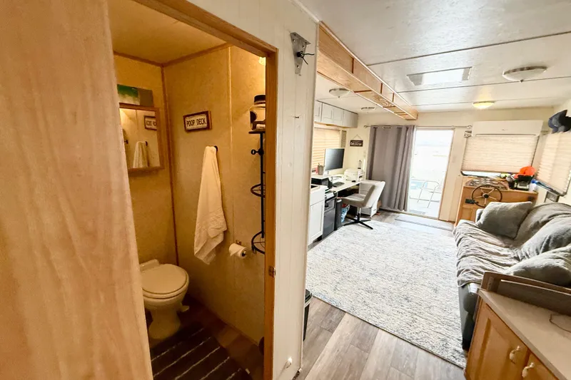Slide: The Image of Interior of a 2006 Myacht 4313 houseboat featuring a cozy living area and bathroom. - 12
