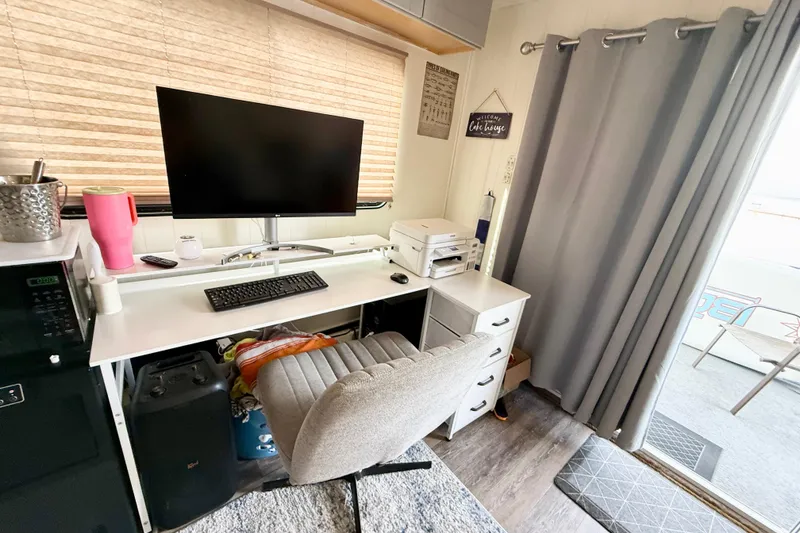 Slide: The Image of Compact home office setup inside a 2006 Myacht 4313, featuring a desk, monitor, and chair. - 14