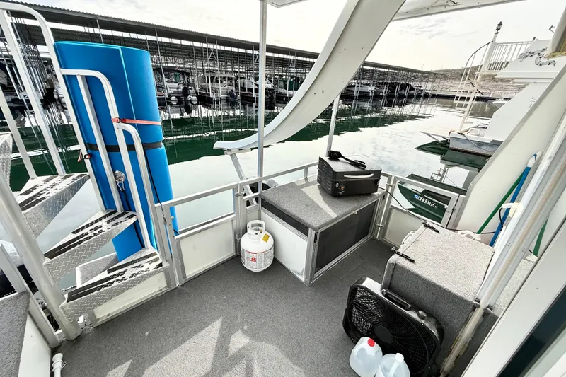 Slide: The Image of 2006 Myacht 4313 houseboat deck with seating, propane tank, and marina view. - 15