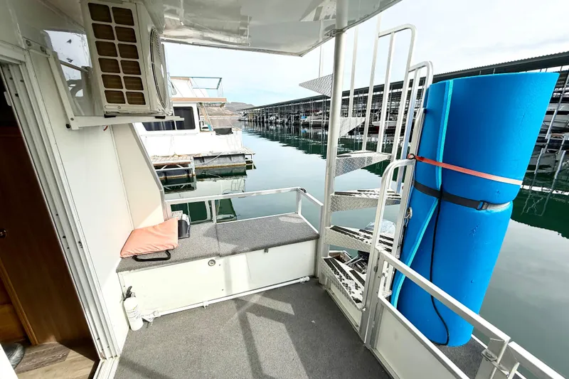 Slide: The Image of 2006 Myacht 4313 houseboat deck with spiral staircase and blue floatation device. - 16