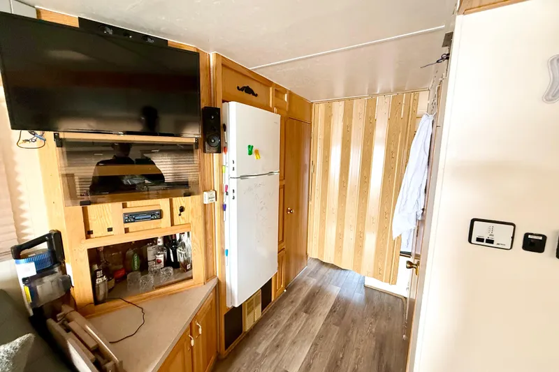Slide: The Image of Interior of 2006 Myacht 4313 with TV, fridge, and wooden cabinetry. - 7