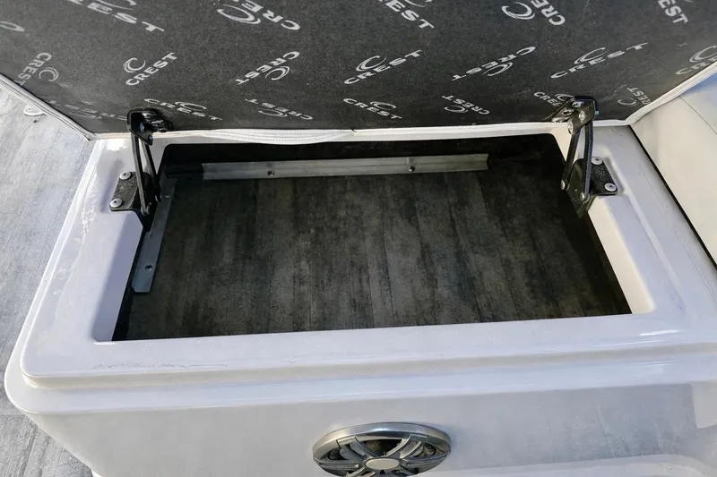 Slide: The Image of Open storage compartment in 2019 Crest 250 LUSD boat, featuring branded interior lining. - 10
